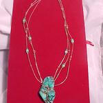 Natural turquoise nugget and beads, natural red coral and sterling silver beads.